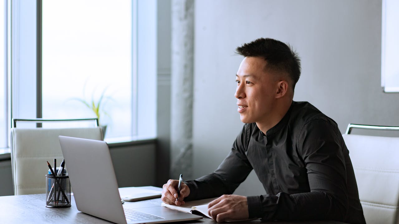 A professional sitting at a desk, reviewing background screening results, including a police check and criminal history check, as part of the hiring process.